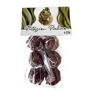 Pistazien Praline – handgemachte Schokoladenpraline mit feiner Pistazienfüllung in transparenter Verpackung.
